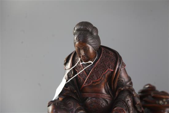 A Japanese wood okimono of the Empress-Consort Jingu seated on a rock, Meiji period, total height 35.5cm